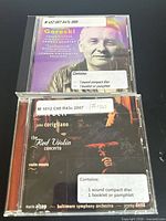 Front view of both CD cases showing titles, performers, and library labels