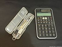 Front view of scientific calculator and open compass set showing contents