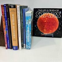 Books standing between wooden bookends with front cover of The Life & Death of Stars visible