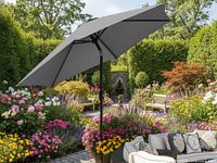 Full view of dark grey patio umbrella open in outdoor setting