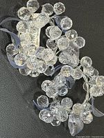 Pair of clear acrylic beaded napkin rings with blue ribbon accents