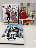 Front covers of all three hardcover graphic novels standing upright