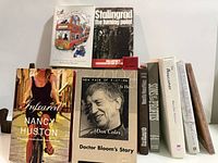 Group shot of eight books displaying covers and stacked spines