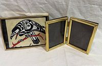 Raven art print in brass frame beside brass hinged double frame