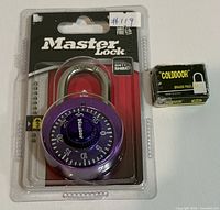 Front view of sealed Master Lock padlock and boxed Golddoor padlock