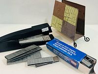 stapler, staples box, loose strips in foreground