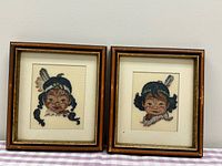 Both framed needlepoint portraits side by side
