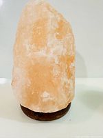 Front view of Himalayan salt crystal on wooden base