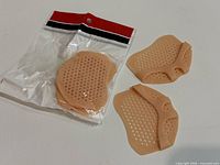 Sealed clear bag containing one pair and two loose silicone pads showing design
