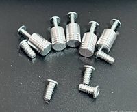 six cylindrical knobs and five screws on black surface