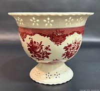 side view showing red floral toile pattern and pierced cut-outs on rim and base