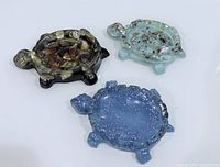 Three turtle resin dishes in varying colours displayed top view