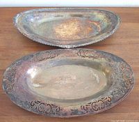 Both silver-plated bread trays side by side showing size and rim designs