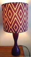 Full view of lamp showing purple hourglass base and patterned drum shade