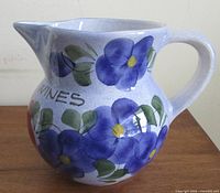 Left side profile showing blue violets, handle, spout
