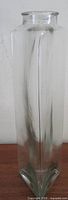 Full front view of tall clear glass vase showing triangular profile