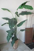 Full view of tall faux Bird of Paradise plant in woven basket