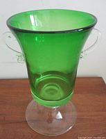 Full view of emerald green trumpet vase on clear pedestal base with handles
