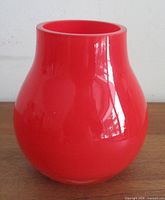 front view of red cased glass vase showing shape and color