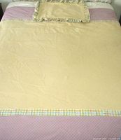 Full view of bedspread on bed with pillow sham placed at head; shows color layout and trim