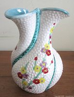 Full front view of Deruta vase showing pebbled surface and floral design