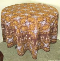 Full view of tablecloth draped on round table showing overall pattern