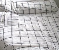 Folded length of white fabric with black grid lines