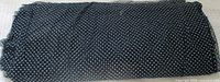 Folded bolt of black fabric with white polka dots