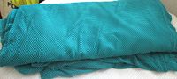 Folded turquoise mesh fabric bolt