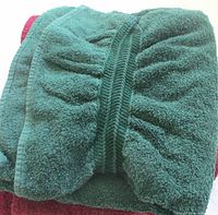Dark green towel folded over burgundy towel