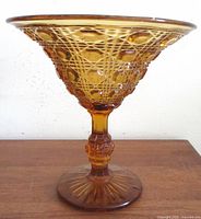 Side view of amber Windsor pattern glass compote on pedestal