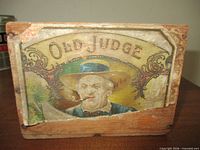 Front view showing Old Judge lithograph label and overall wear