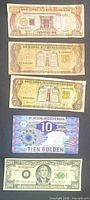 Group of five banknotes stacked: 100 pesos oro, two 20 pesos oro, 10 gulden, novelty $2001