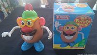 Front view of assembled Mr. Potato Head beside box