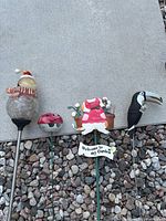 Four garden stakes laid on gravel and mat