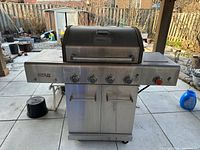 Front view of Nexgrill Revelry barbecue showing exterior, control panel, side shelves and cabinet