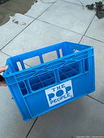 Angle view of blue The Pop People plastic bottle crate showing logo and interior dividers