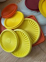 Stacked yellow starburst lids with red, orange and clear lids visible