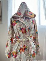 Front view of hooded floral cotton robe on dress form