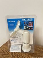 Front of sealed package showing Tiny Tornado personal travel fan