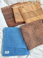 Four vintage towels folded on surface showing colors and patterns