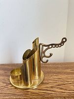 Brass organizer side view showing cylindrical holders and attached cast iron hook