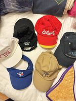 Group shot of all six hats laid out on bed