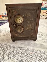 Front view of cast iron toy safe coin bank showing two rotary dials and door