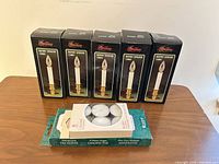 Five boxed battery-operated taper candles with three packs of white tea light candles