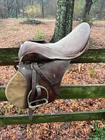 Left side view showing overall saddle, suede knee pad, stirrup iron