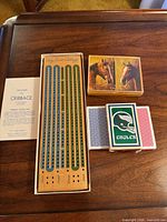Top view: cribbage board in box, rules leaflet, horse artwork card set, Eagles card set