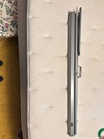 Closed Da-Lite Flyer cassette projection screen shown full length on mattress