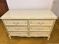 Front view showing six drawers, gold trim, silver pulls