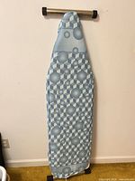 Front view of ironing board showing blue geometric cover
